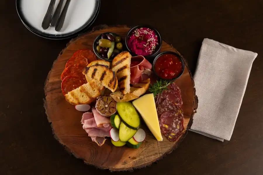 A shared grazing board of cured meats, cheese and pickles